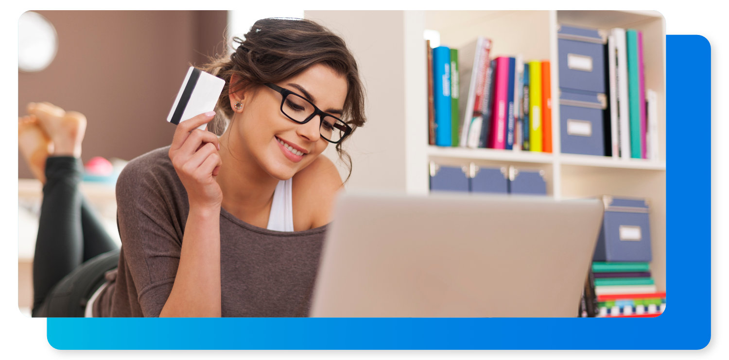 Woman on laptop holding credit card ready to buy clear aligners