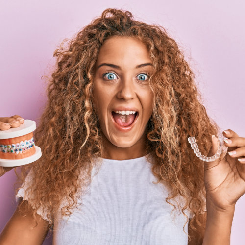 A woman holding the best clear aligners and teeth.