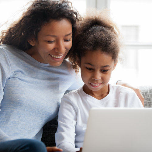 Women with daughter Looking up financial options for clear aligners on a laptop.